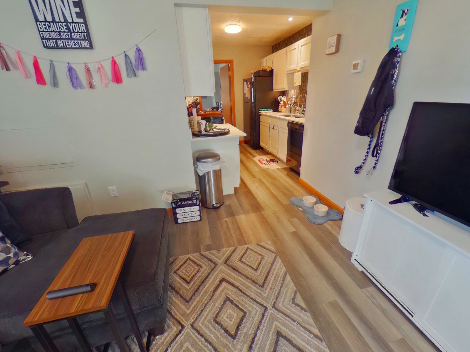 A living room with a sign on the wall that says wine.