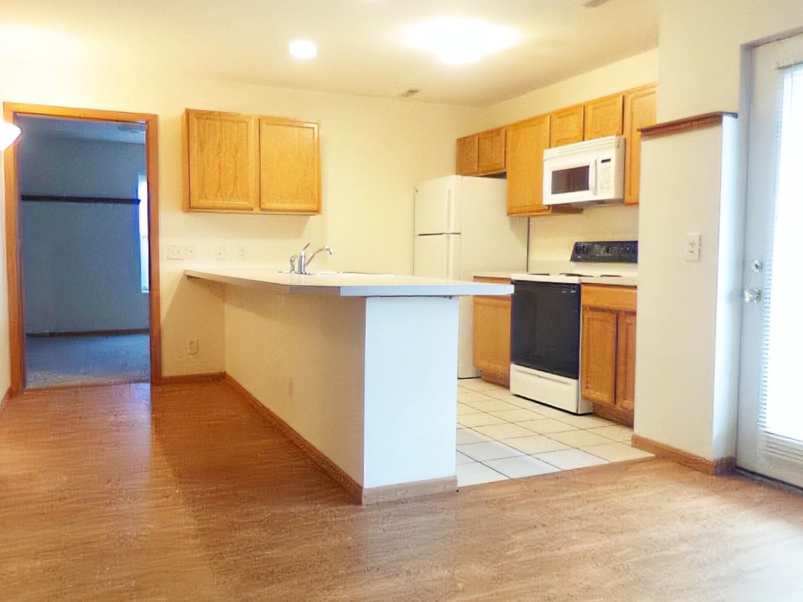 A kitchen with a refrigerator, stove, microwave, and sink.