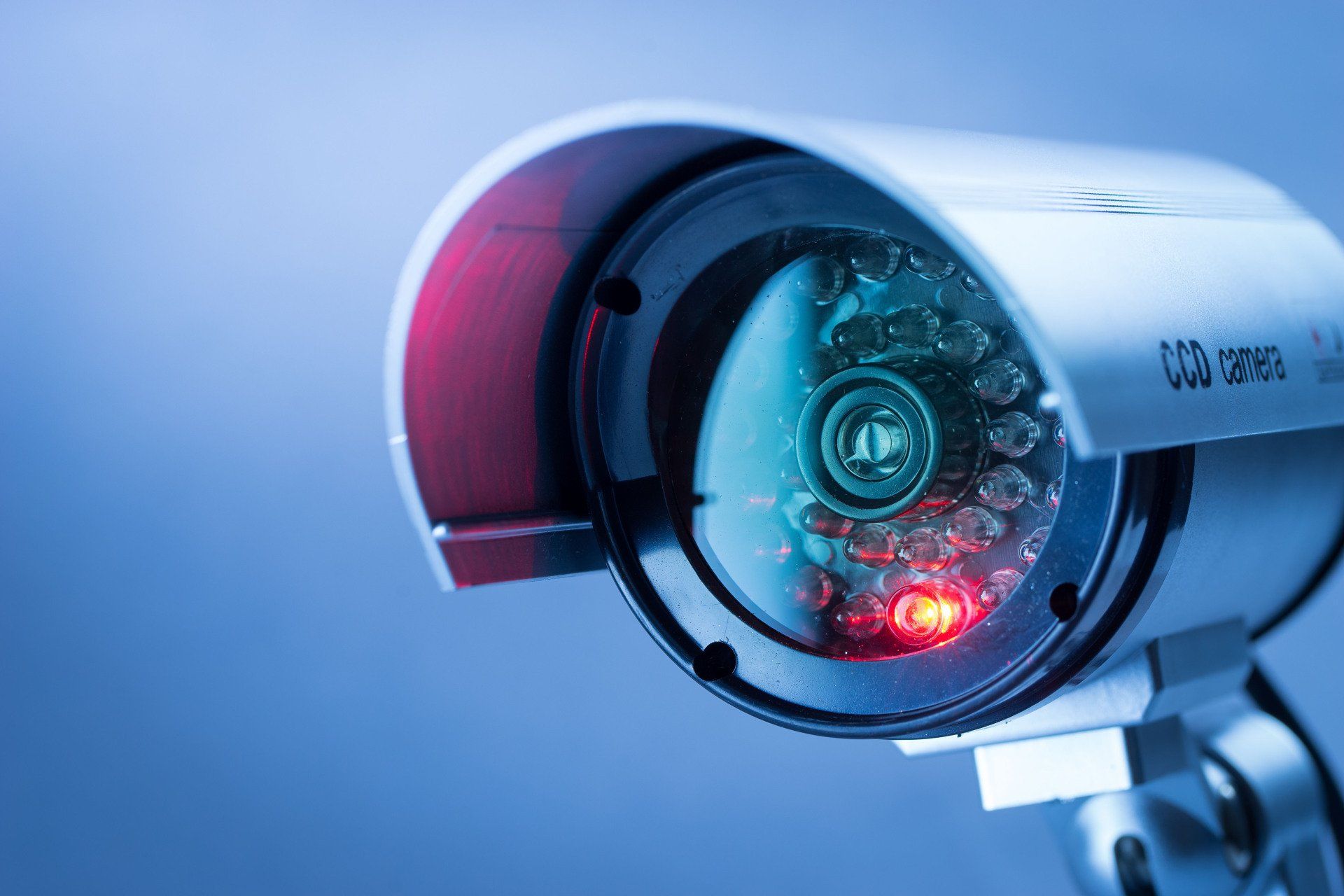 A close up of a security camera with a red light on it.