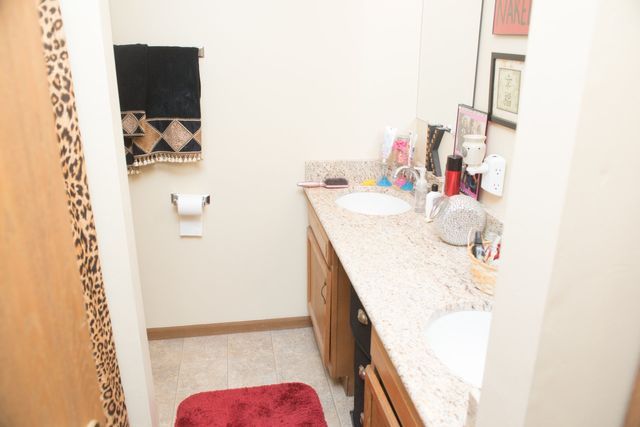 A bathroom with two sinks and a red rug.