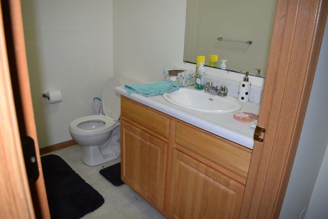 A bathroom with a sink, toilet, and mirror.