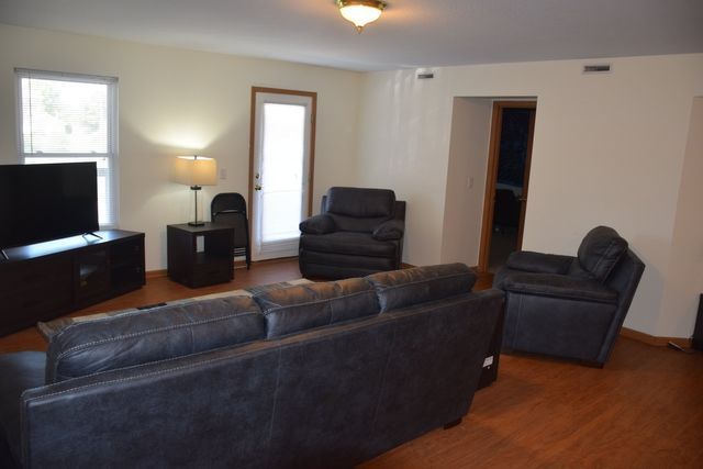 A living room with a couch, chair, and TV.