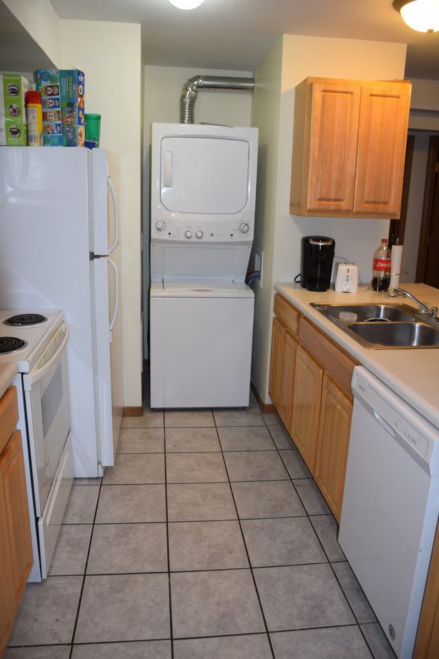 A kitchen with a washer and dryer stacked on top of each other.
