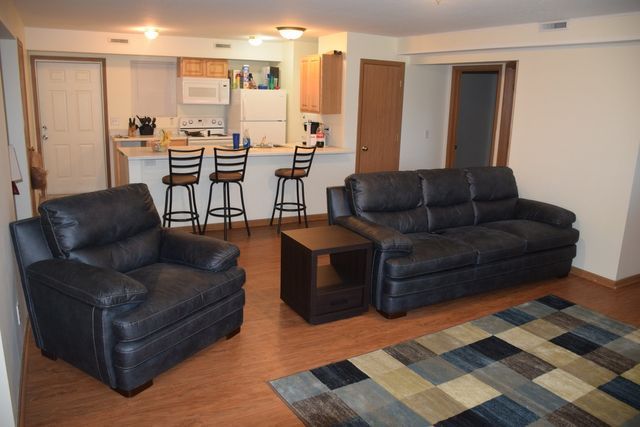 A living room with a couch and two chairs.