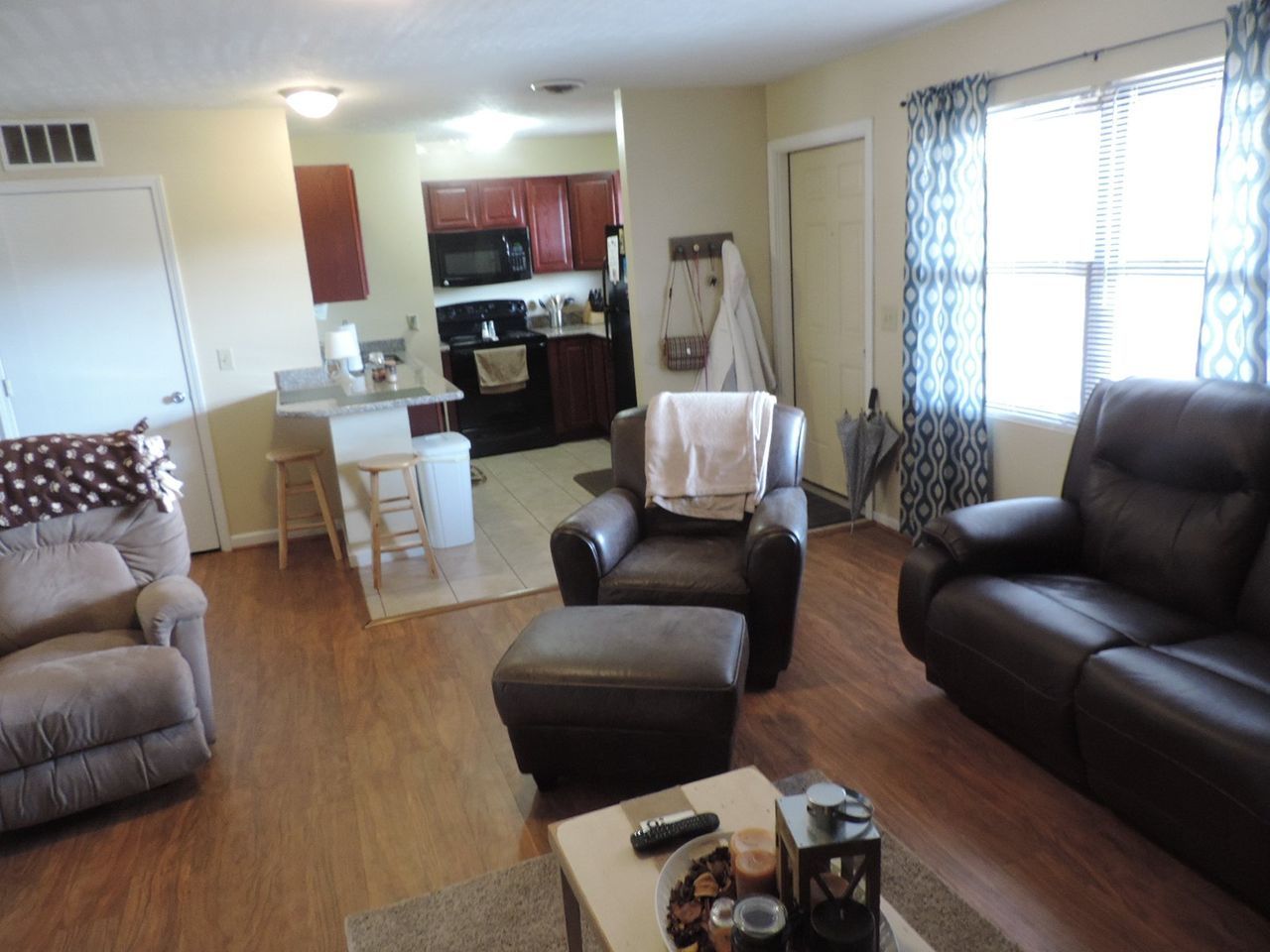 A living room with a couch and two chairs.