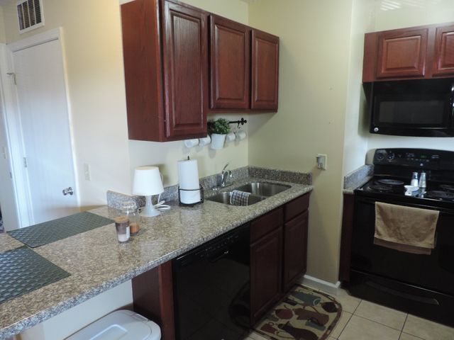 A kitchen with a sink stove and microwave.
