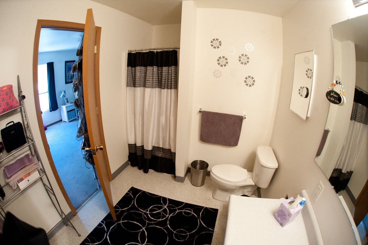 A bathroom with a toilet, sink, and shower curtain.