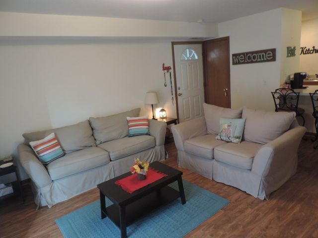 A living room with a welcome sign above the door.