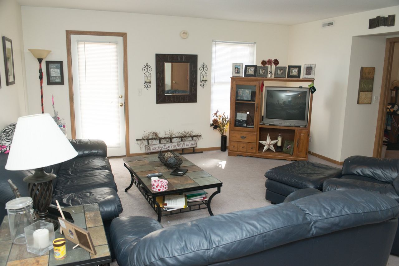 A living room with a blue couch and a flat screen TV.