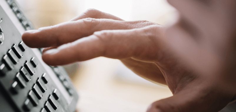 A person's hand pressing buttons on a keypad.