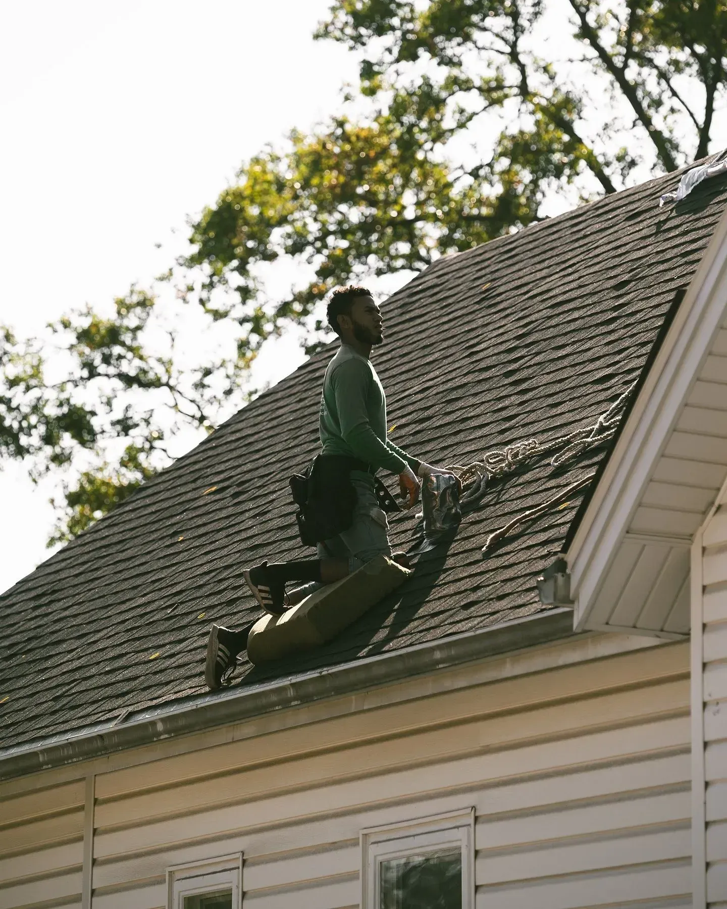 A man is standing on the roof of a house.