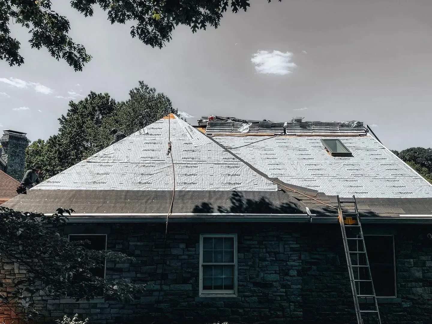 A ladder is attached to the roof of a house.