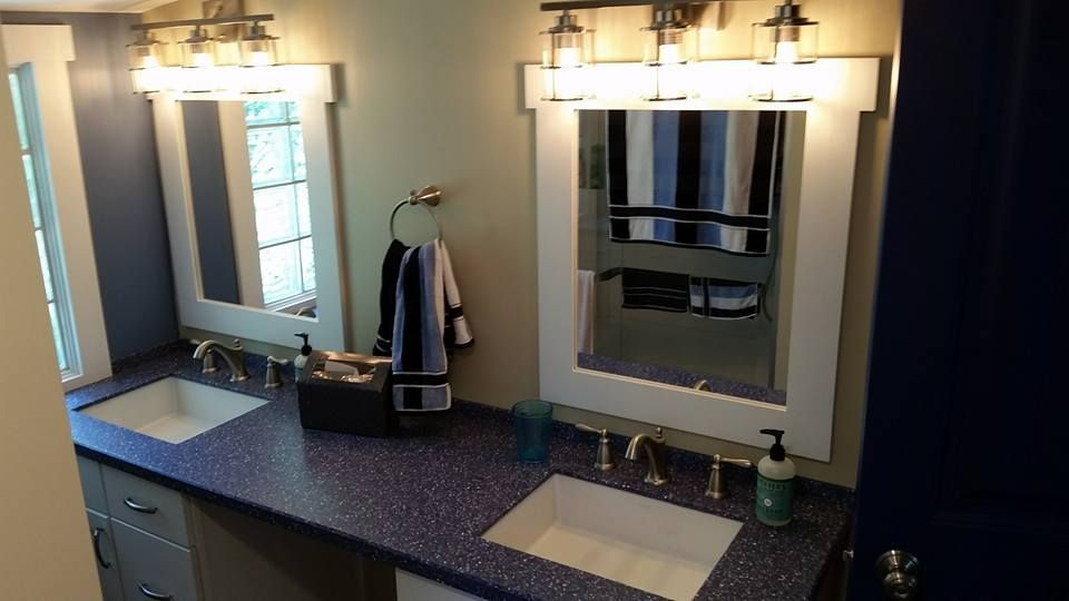 Bathroom with two sinks, blue countertop, white framed mirrors, and chrome fixtures.