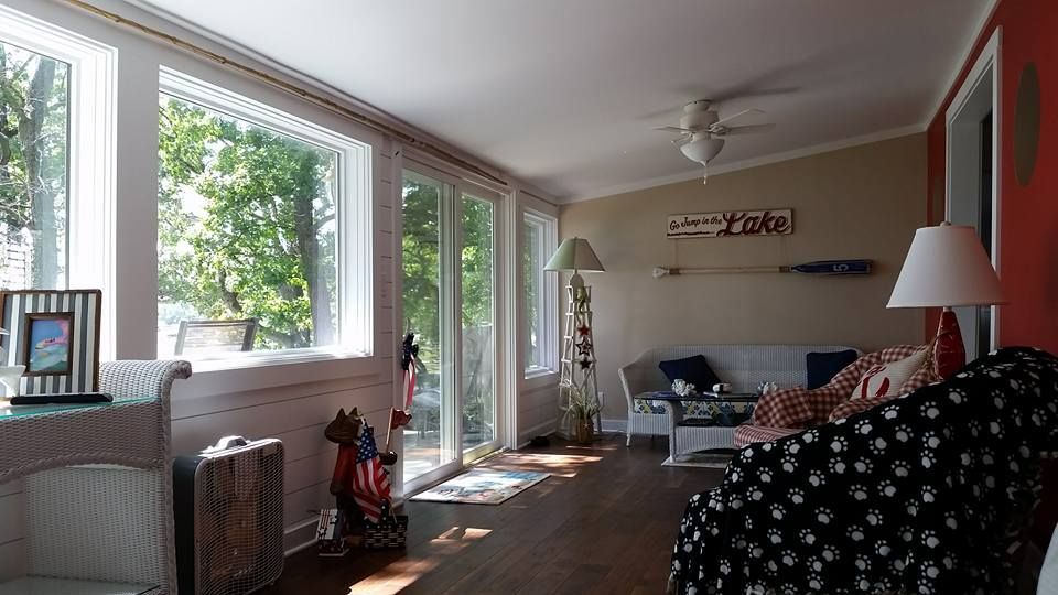 Sunroom with large windows, wicker furniture, and nautical decor.