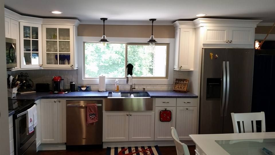 Kitchen with white cabinets, stainless steel appliances, and a window over the sink.
