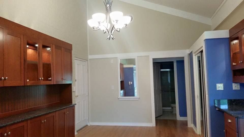 Kitchen with dark wood cabinets, a chandelier, and a blue wall.