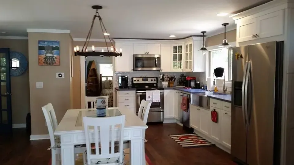 Kitchen with white cabinets, stainless steel appliances, and a dining table.
