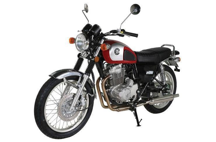 A red and silver retro-style motorcycle parked on a stand against a plain white background.