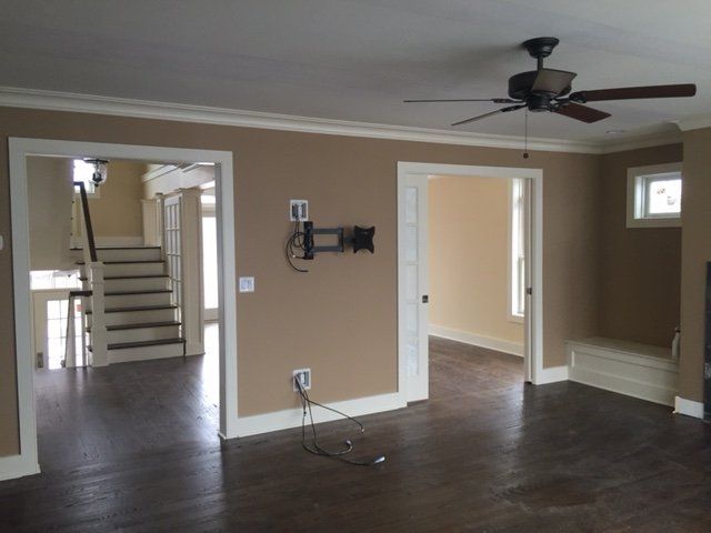 A living room with a ceiling fan and unfinished electrical wirings