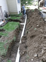 A man is standing in the dirt next to a house