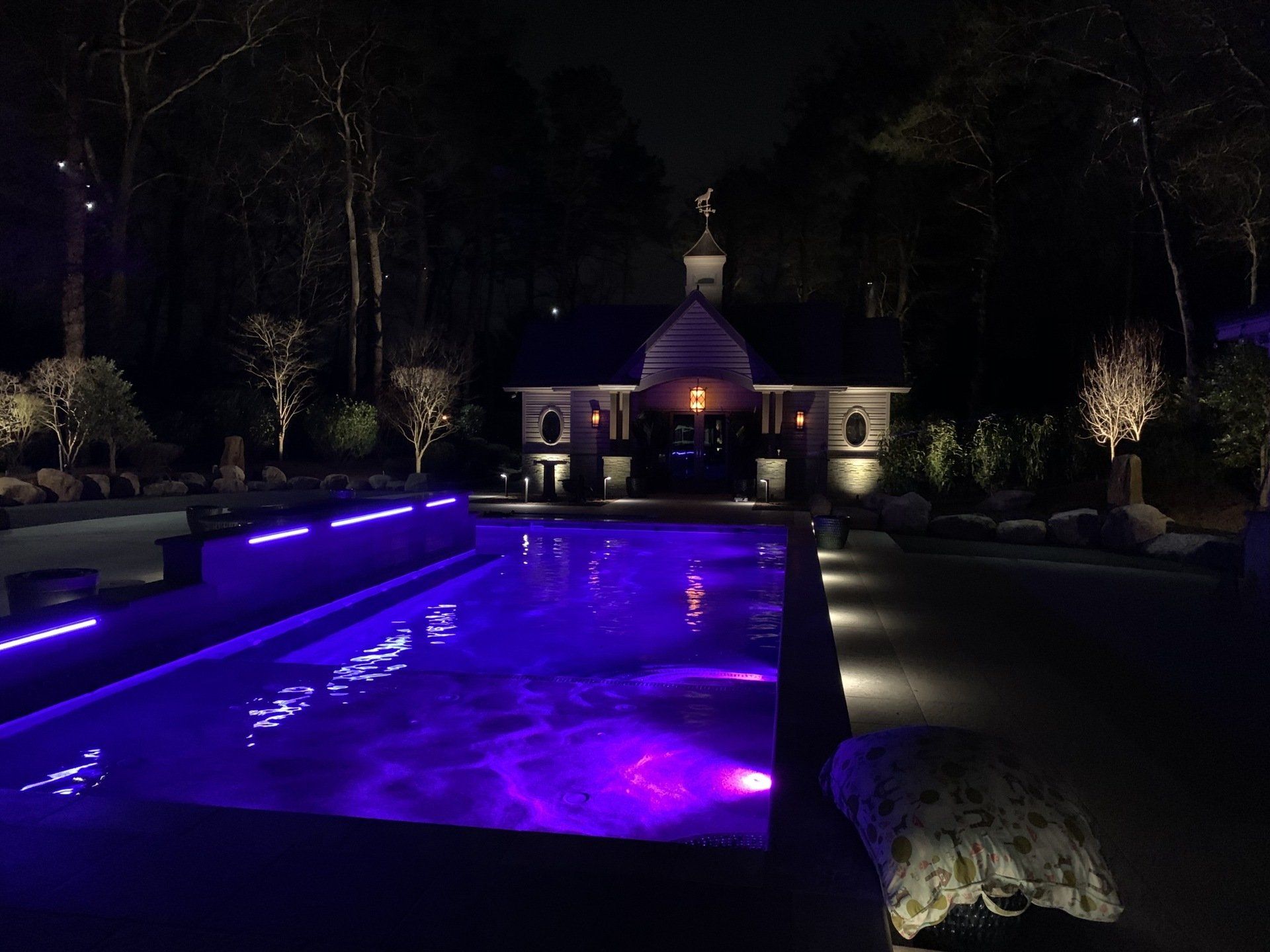 A large swimming pool with purple lights