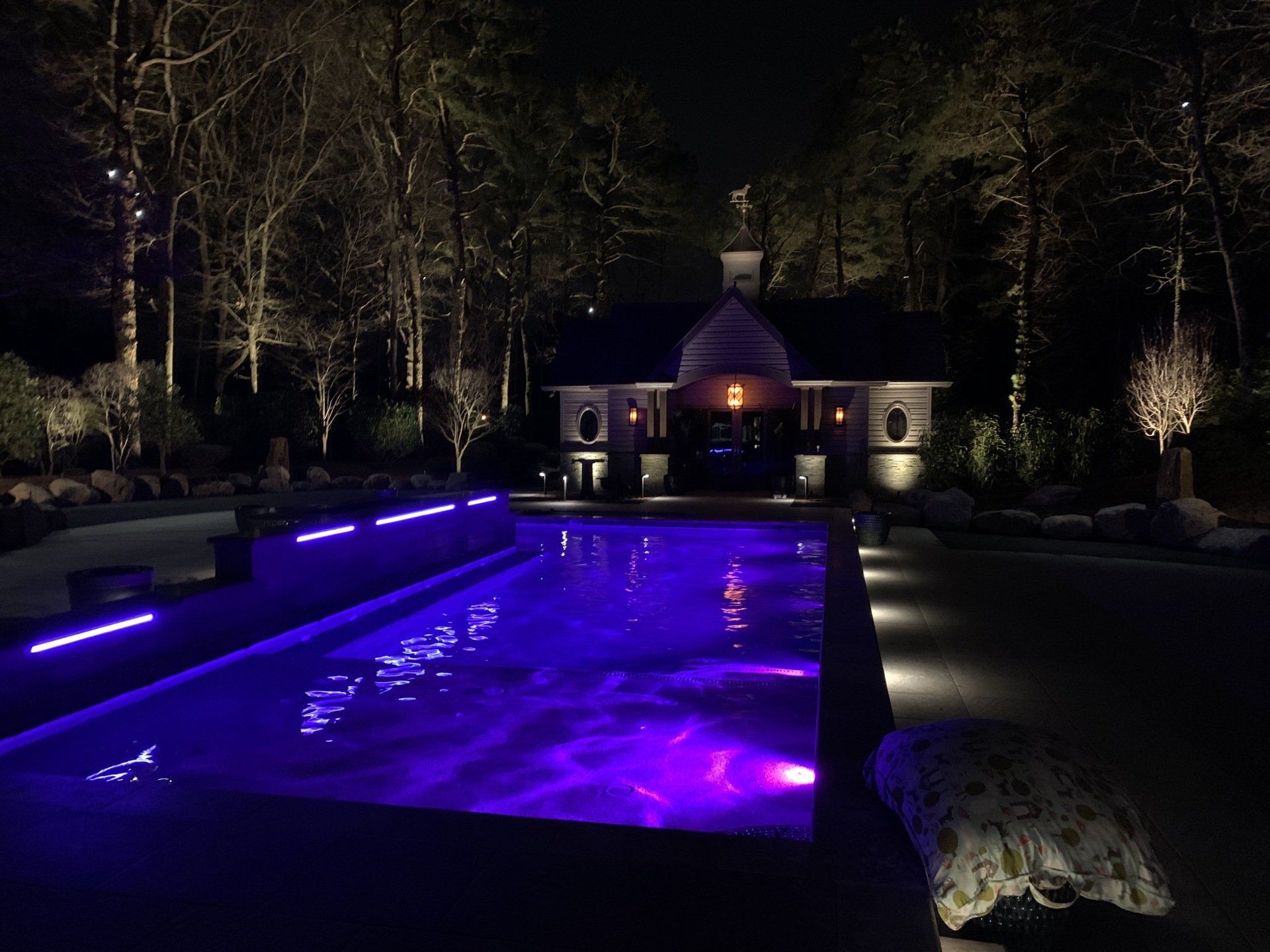 A large swimming pool with purple lights