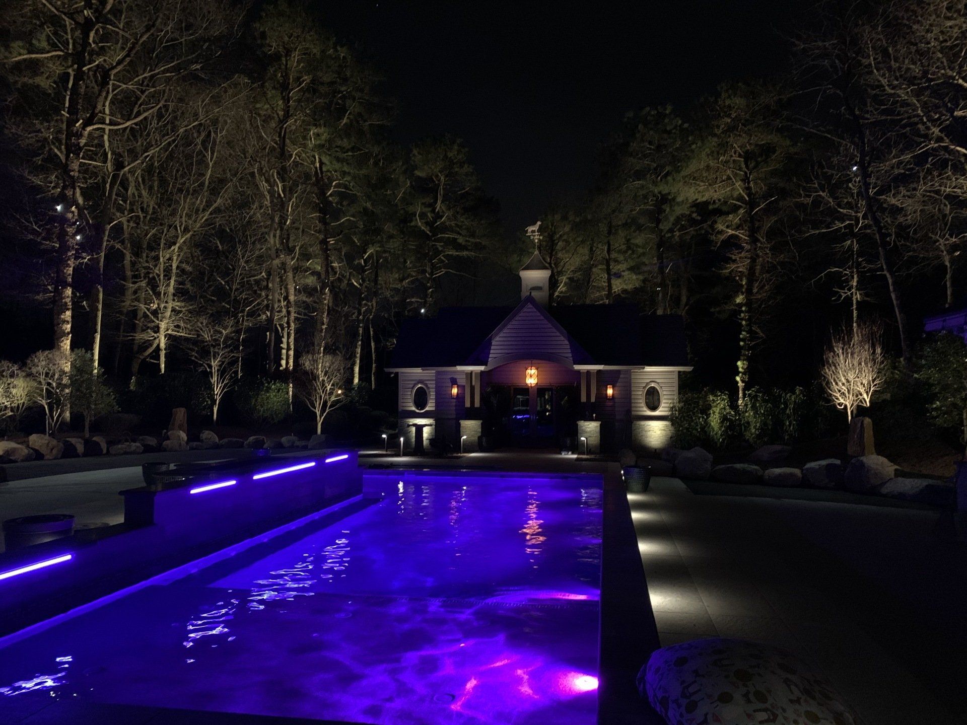 A large swimming pool with purple lights