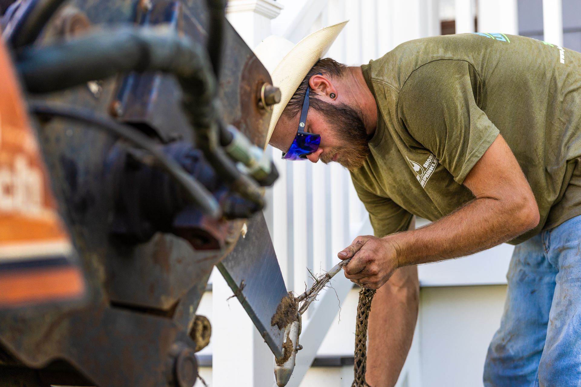 A man wearing a hard hat and goggles is working on a machine