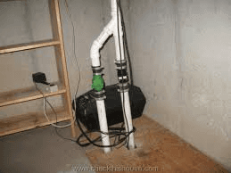 A pump is sitting in a basement next to a wooden shelf
