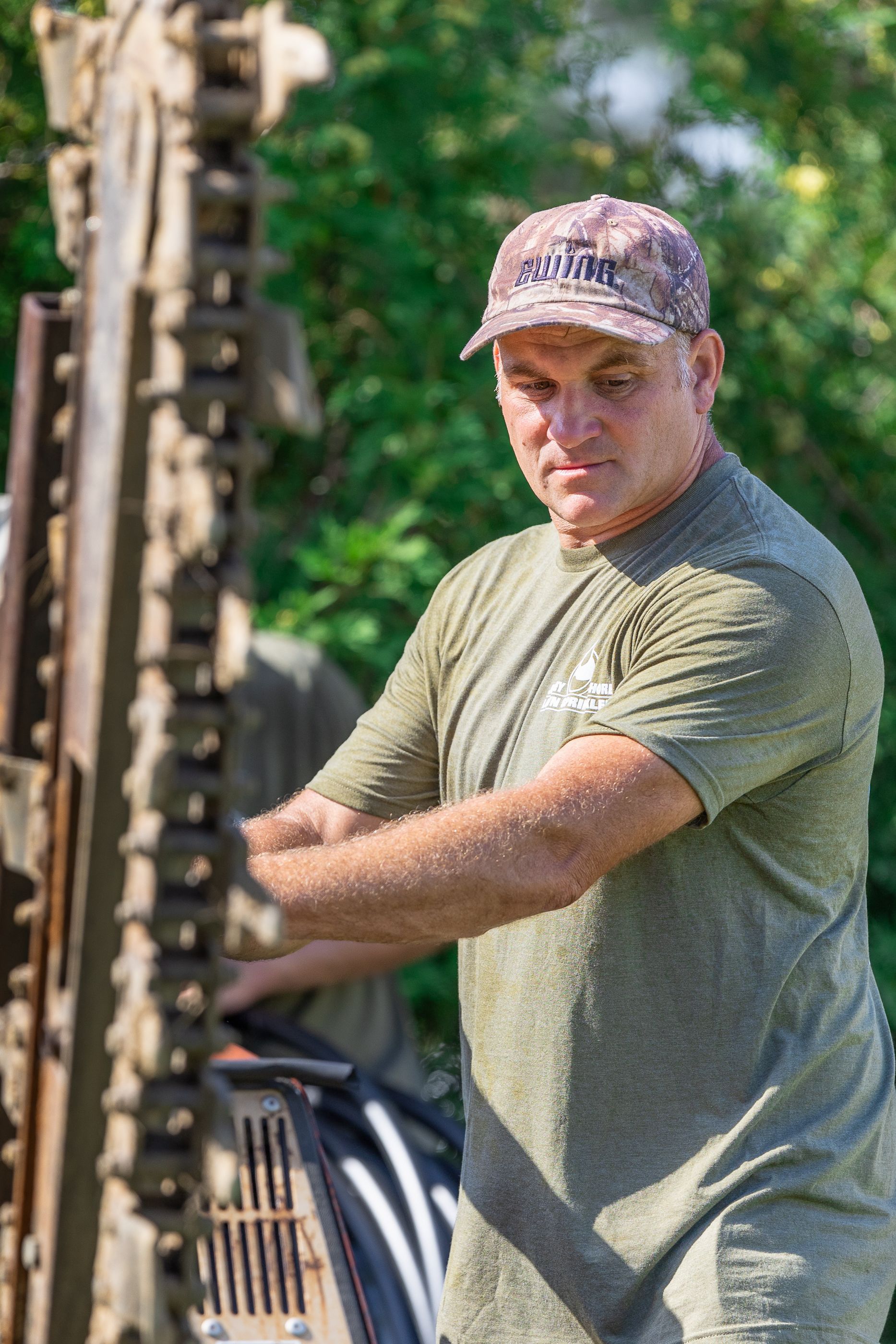 A man in a green shirt is working on a piece of equipment