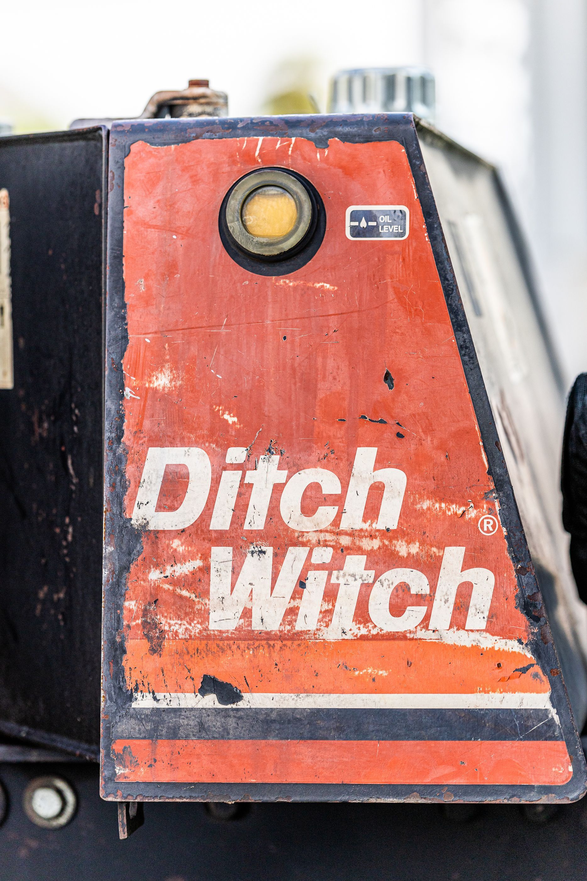A red and black tractor with a sign on it