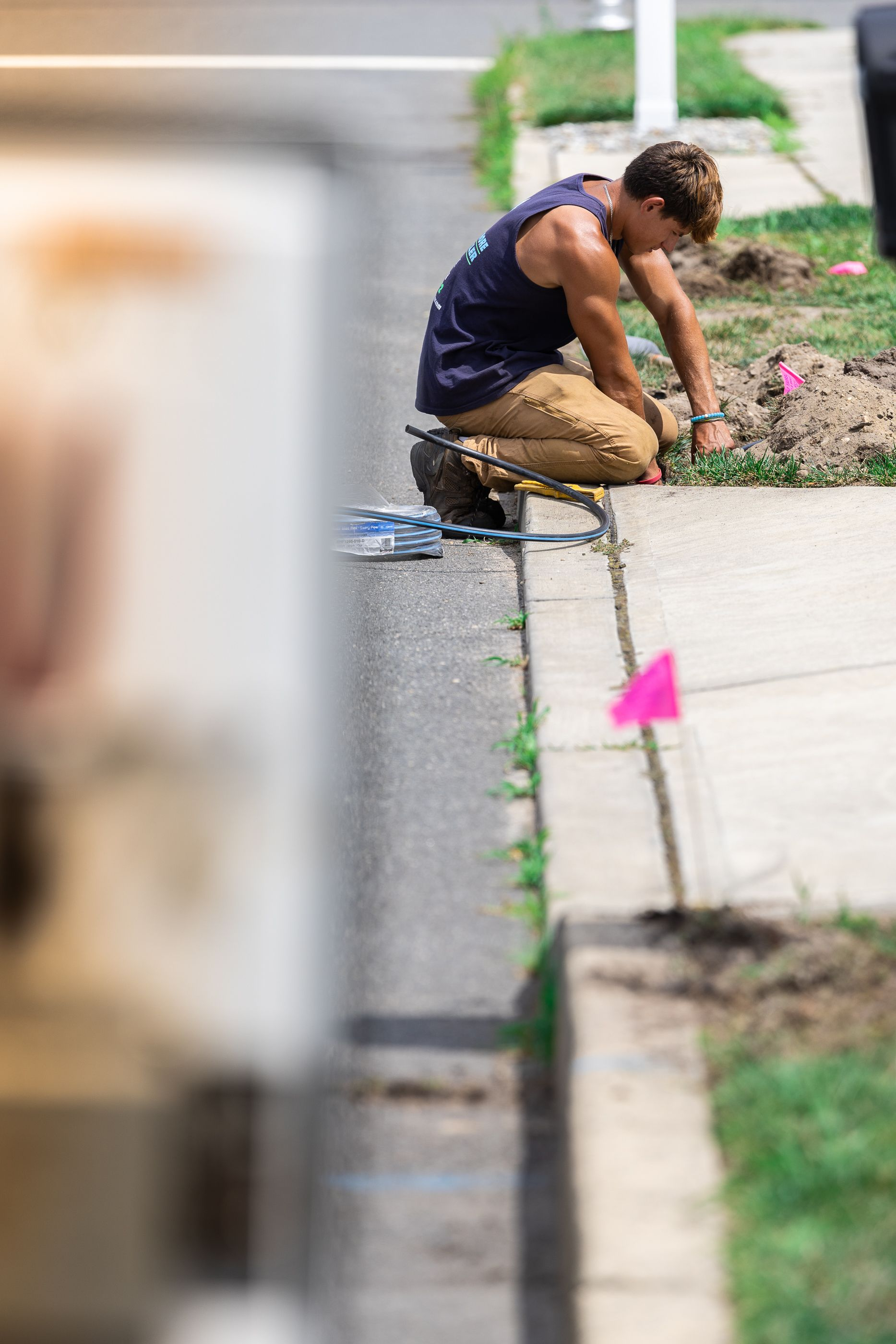 A man kneeling on the sidewalk