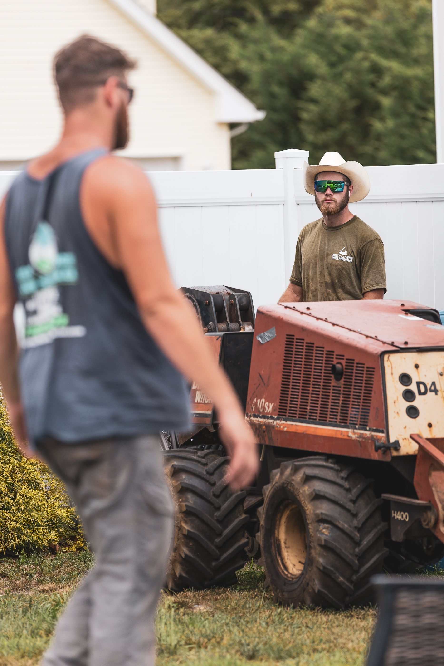 Jersey Shore Lawn Sprinkler workers working on a tractor