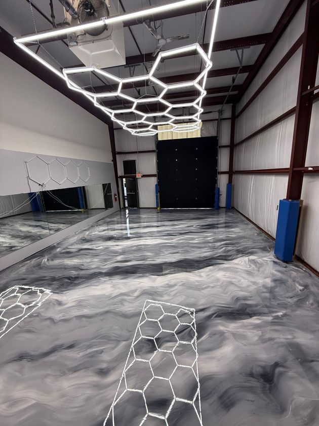 Empty hallway with speckled gray floor and a dark doorway frame