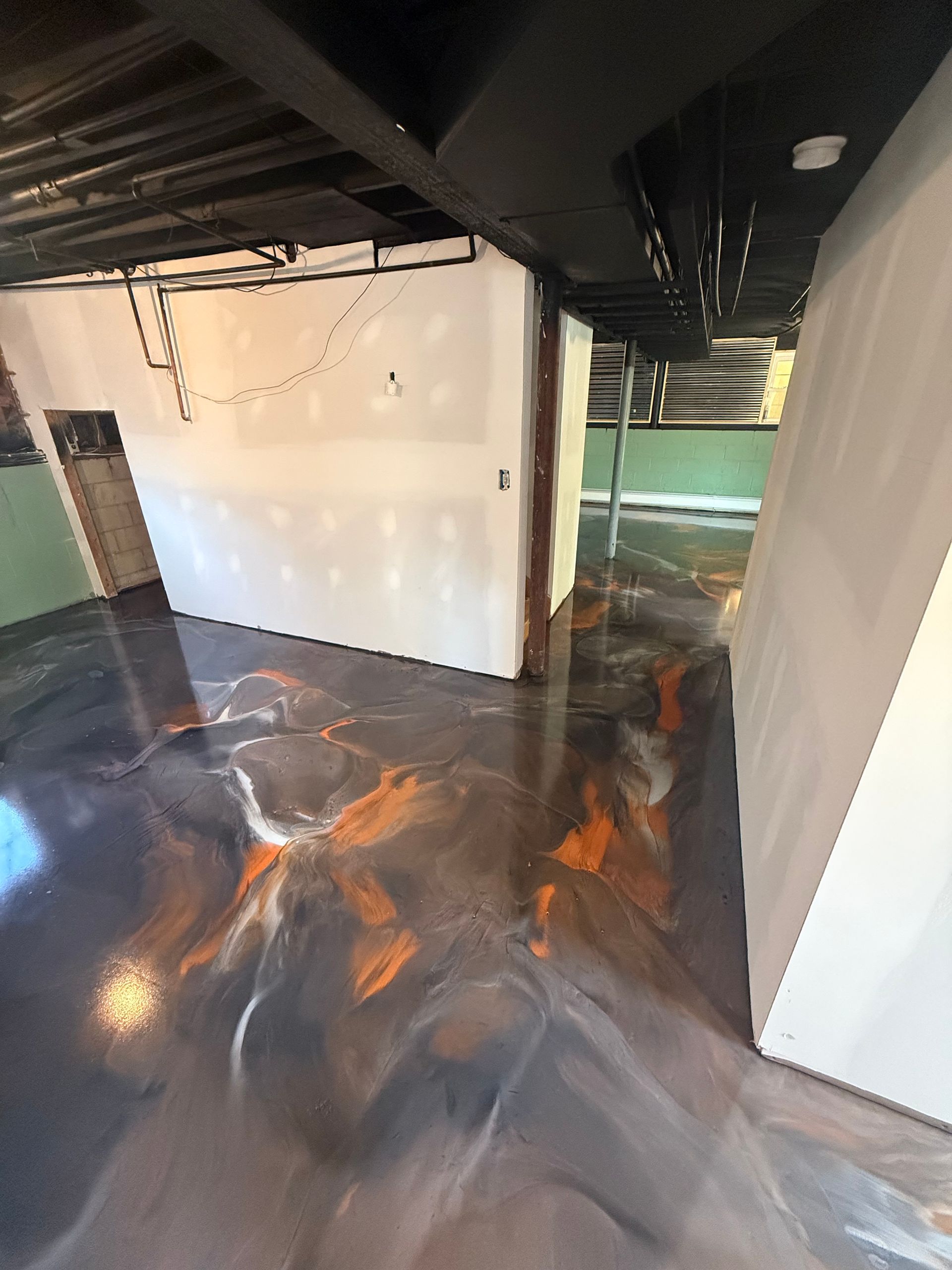 Flooded basement hallway with dark water and exposed ceiling beams