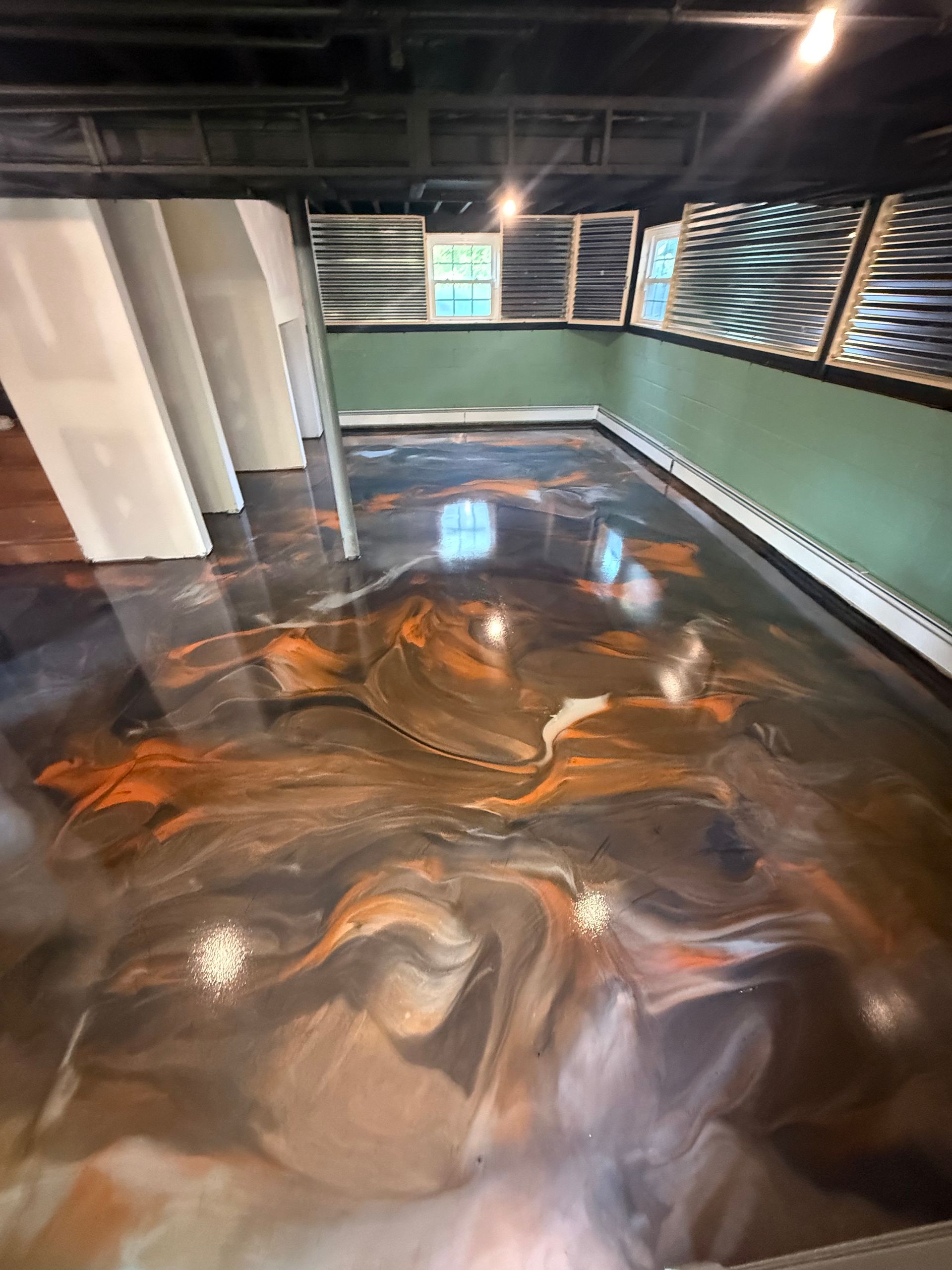 Indoor soaking pool with swirling dark water, green walls, and reflective windows under warm lights