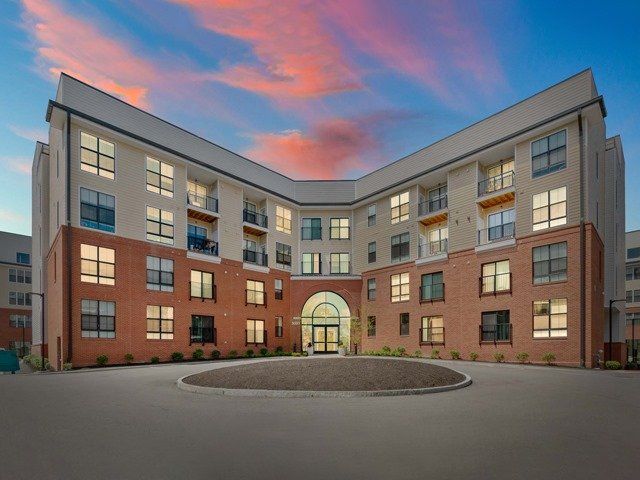 A large apartment building with a lot of windows is lit up at night