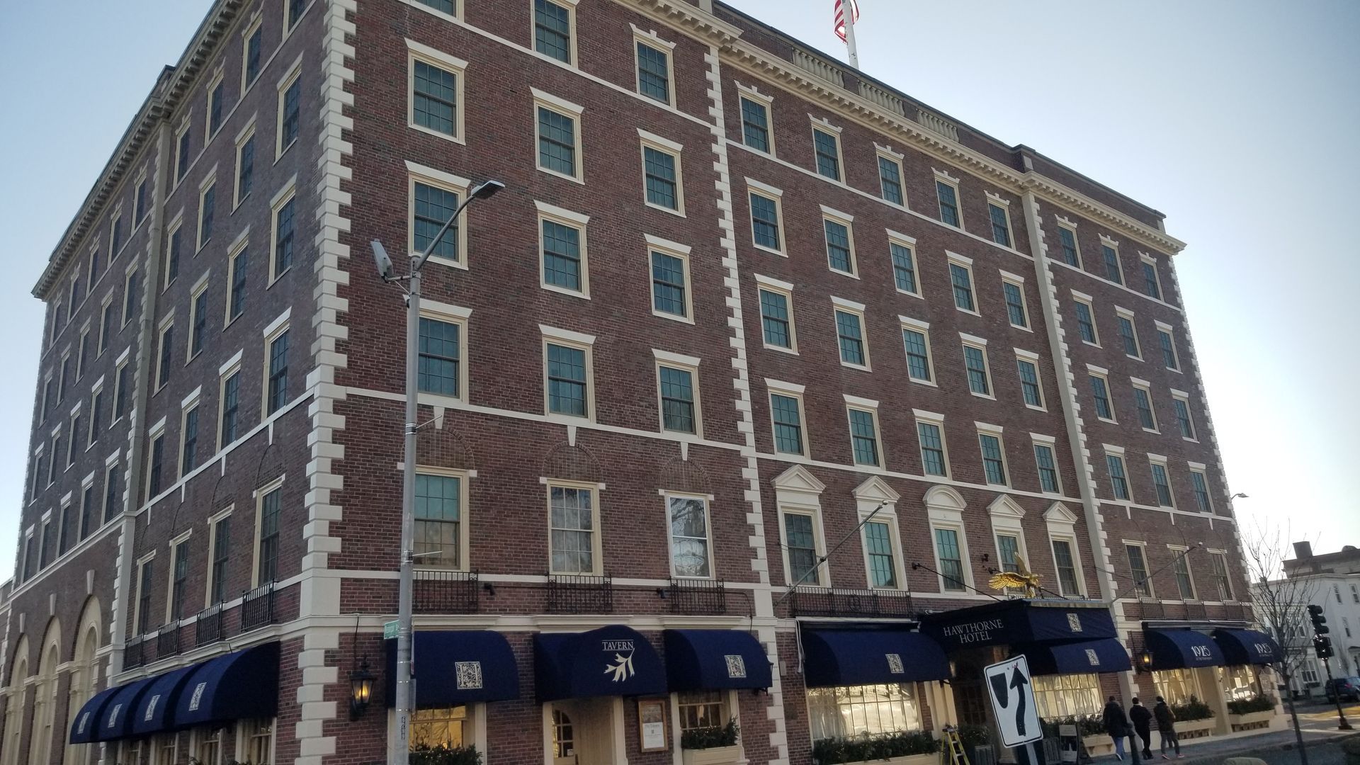 A large brick building with blue awnings on the side of it.