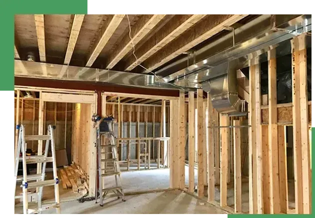 Interior under renovation with exposed wooden framing, beams, ladders, and construction tools