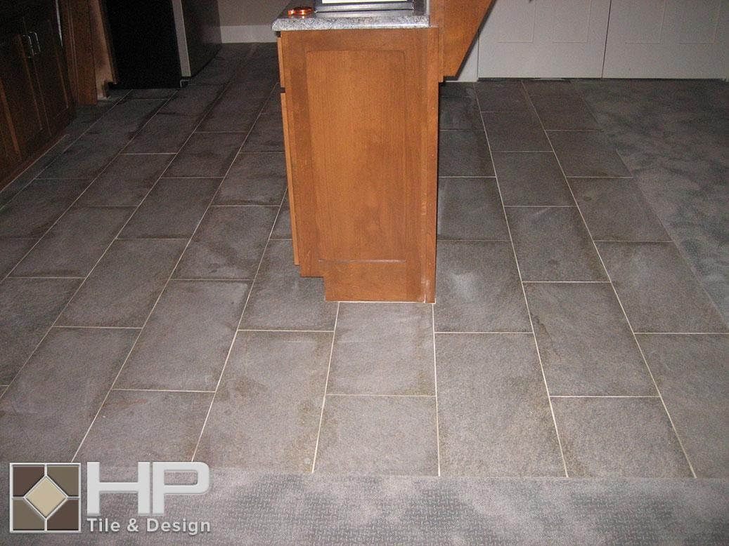 Gray tile floor with light grout lines; a wooden cabinet is in the middle