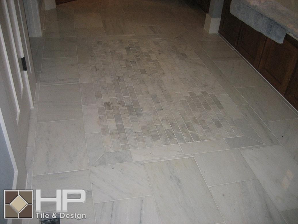 Light-colored tile floor with a darker tile inset; bathroom interior