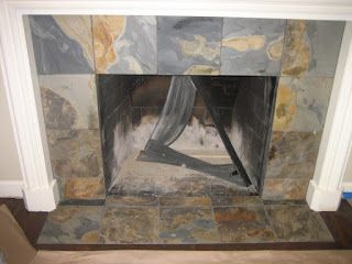 Fireplace with slate tile surround and white mantel. Interior shows firebox with damper.