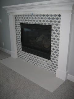 Fireplace with black insert and white surround; gray and white diamond tile.
