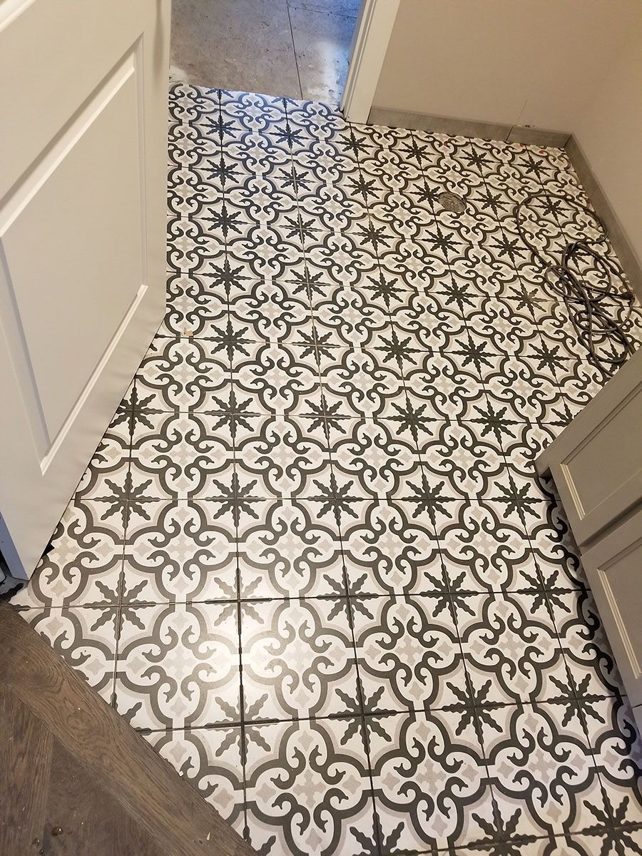 Bathroom floor with patterned black, gray, and white tile