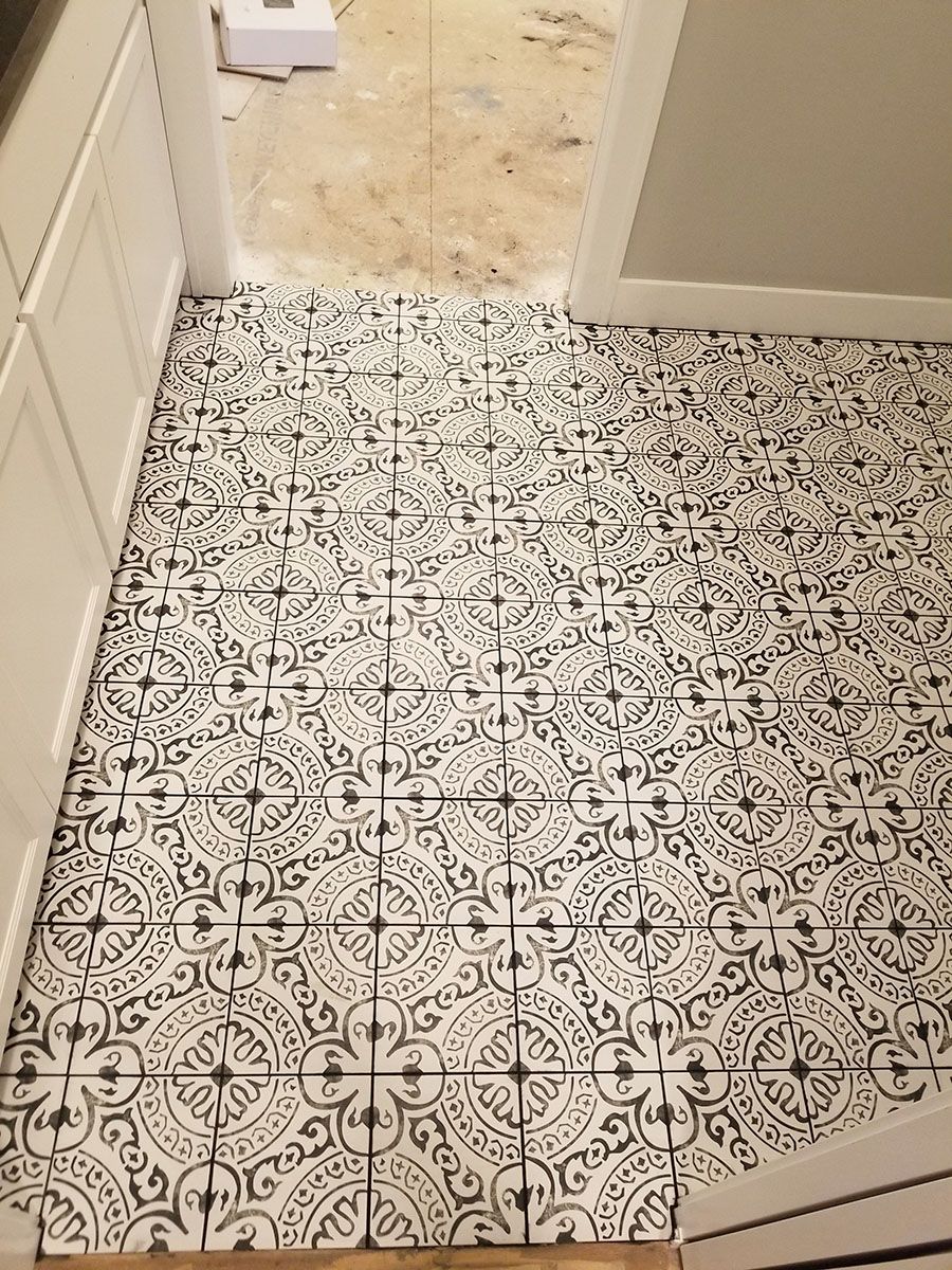 Black and white patterned tile flooring installed in a room