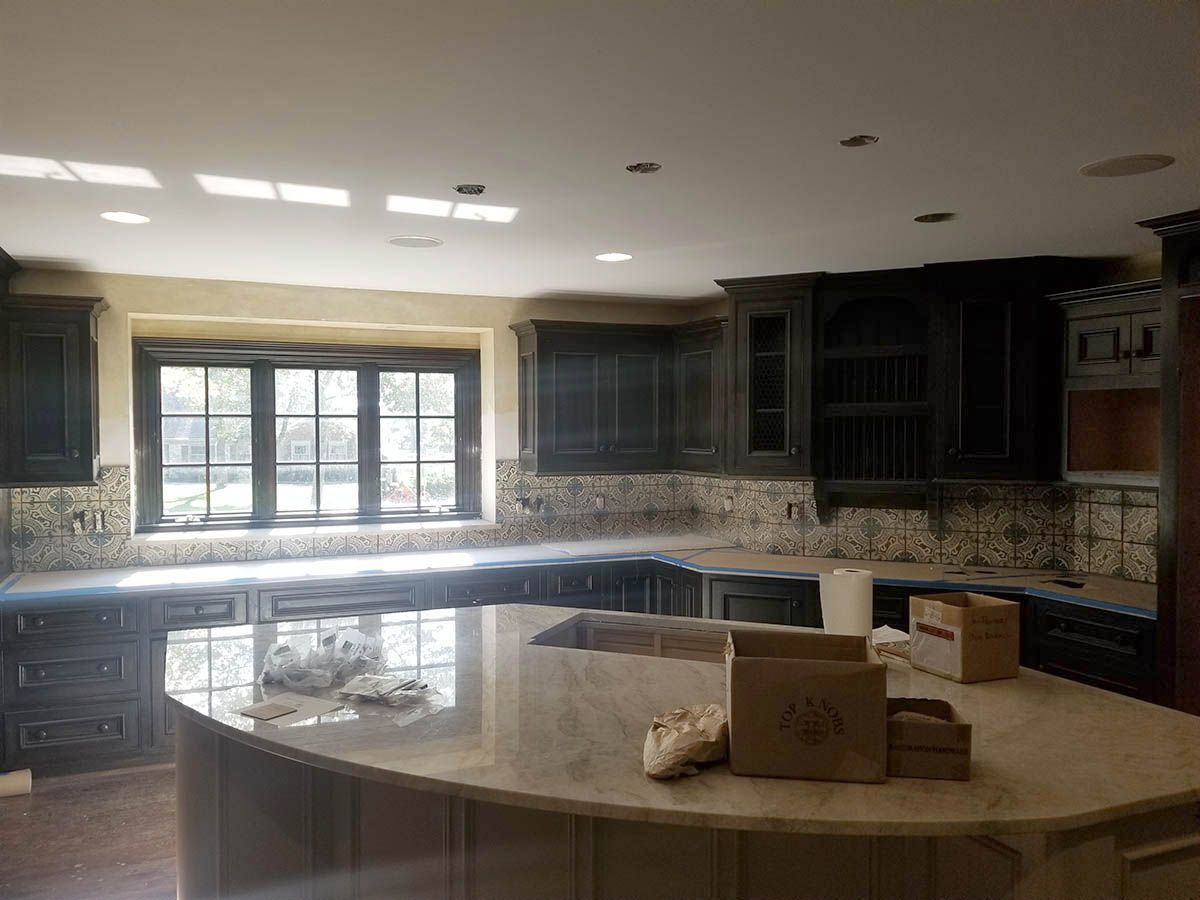 Kitchen with dark cabinets, light countertops, and large island