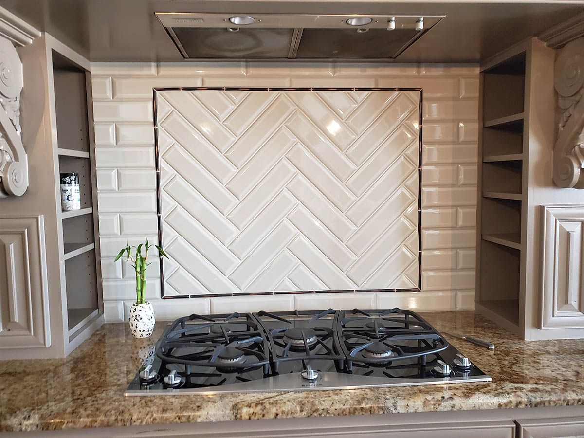 Kitchen backsplash with herringbone pattern, above a stovetop