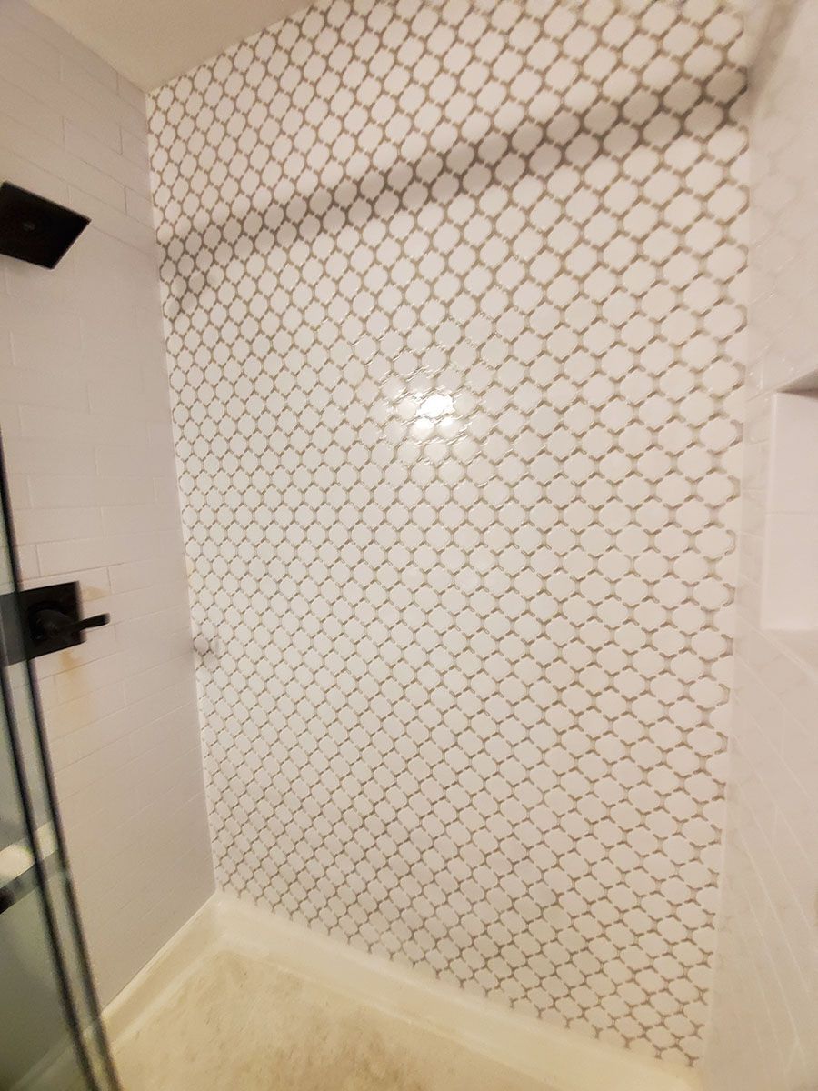 Shower wall with white and gray patterned tile