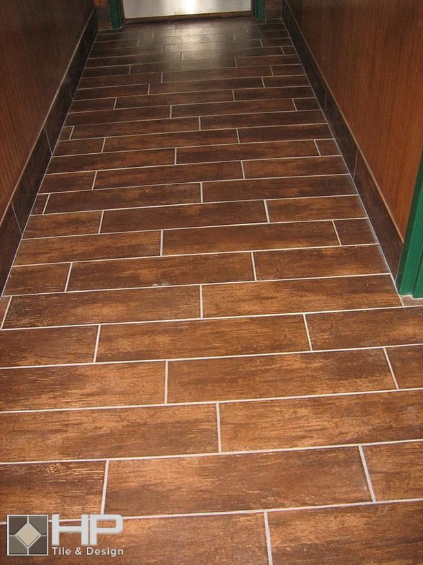 Brown wood-look tile floor in a hallway with brown and green walls