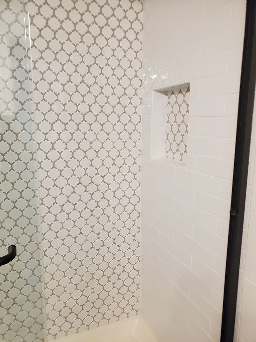 Shower with patterned tile wall and built-in niche